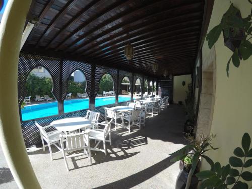 a row of tables and chairs next to a swimming pool at Riad Zahra in Essaouira