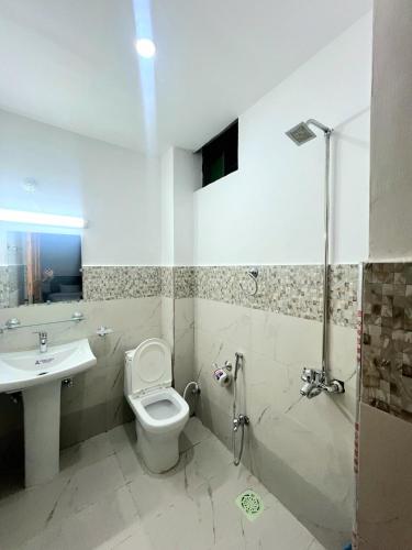 a bathroom with a toilet and a sink at The Canvas Hotel in Abbottabad