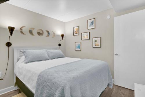 a bedroom with a white bed and pictures on the wall at Seawind Sanctuary in Carolina Beach
