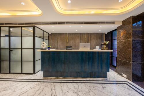 an office lobby with a reception desk with a laptop on the counter at Hotel Anu Plaza - Newly Built Hotel With Parking Just 6 Mins from Connaught Place ,New Delhi Railway Station & Metro Station in New Delhi
