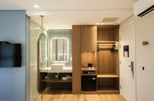 a bathroom with a sink and a mirror at Intercity Florianopolis in Florianópolis
