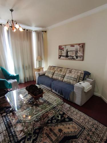 a living room with a couch and a coffee table at Centro, Rua Coberta, perto de tudo! in Gramado
