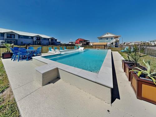 a swimming pool with tables and chairs in a yard at Inn at Dolphin Bay in Rockport