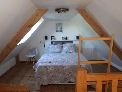 a bedroom with a bed in a attic at Gites laurent in Guissény