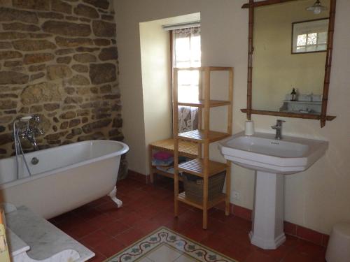 a bathroom with a tub and a sink and a mirror at Gites laurent in Guissény