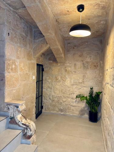 a room with a stone wall and a potted plant at VillageStay in Rabat