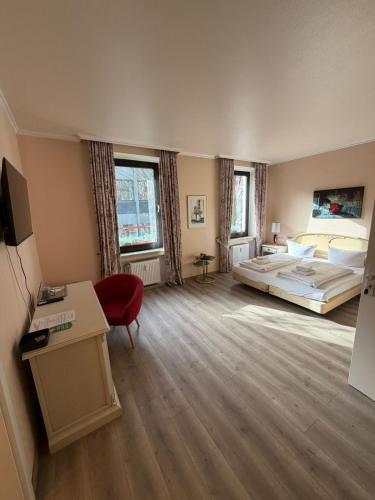 a large room with a bed and a desk at Hotel City Check In - günstig & flexibel Tageweise und Wochenweise möglich in Heiligenhaus