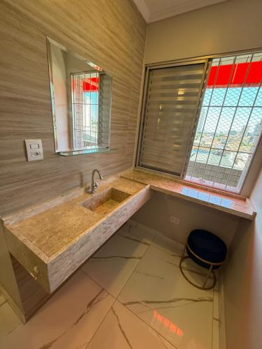 a bathroom with a large sink and a mirror at Hotel Mustang in São Paulo