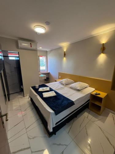 a bedroom with a bed with two towels on it at Hotel Mustang in São Paulo