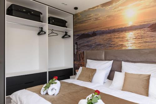 a bedroom with two beds and a painting on the wall at Rusulica Trogir in Seget Vranjica