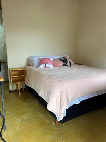 a bedroom with a bed with two pillows on it at Chalé da Janela in Lavras Novas