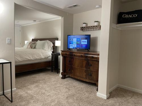 a bedroom with a bed and a television on a dresser at The Cabin on Overland in Prescott