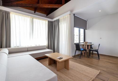 a living room with a white couch and a table at Creta Elena in Chania