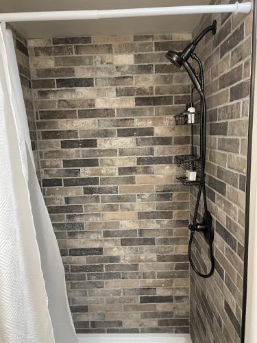 a shower with a brick wall in a bathroom at The Cabin on Overland in Prescott