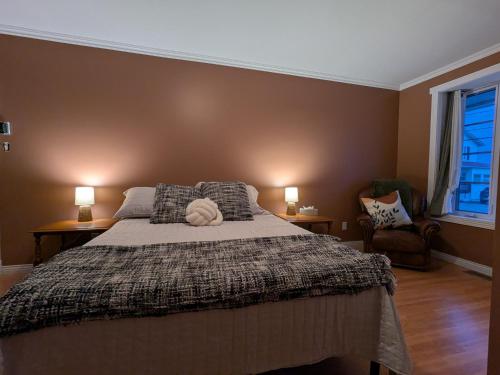 a bedroom with a large bed with two lamps at La belle ancestrale in Sainte-Anne-des-Monts