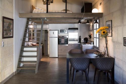 uma cama alta numa cozinha com mesa e cadeiras em Appartements "La Chambre D'Ami" em Arles