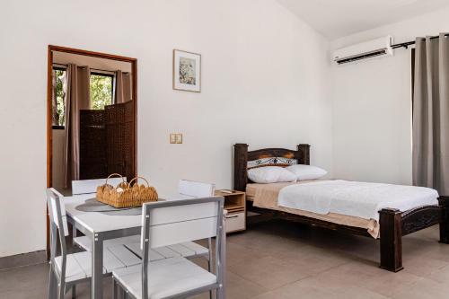a bedroom with a bed and a table with a chair at Casa Paula in Liberia