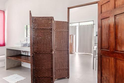 a bathroom with a wicker door in a room at Casa Paula in Liberia