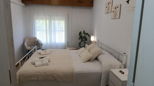 a white bedroom with a large bed in a room at Bosquet de l'Auró in Argençola
