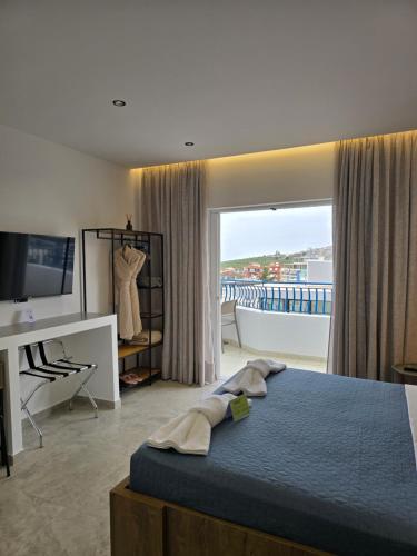 una camera da letto con letto e vista su un balcone di Golden Rays Suites a Sarandë