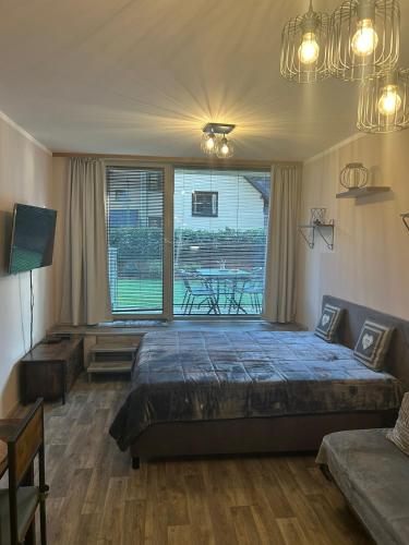 a bedroom with a bed and a table and a window at Apartmán Míša in Harrachov