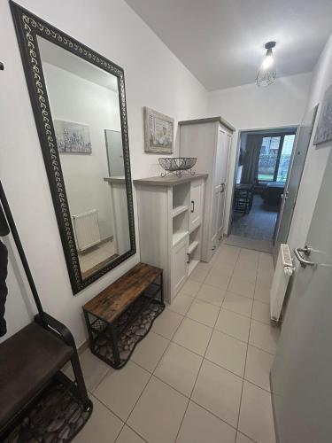 a bathroom with a mirror and a sink and a chair at Apartmán Míša in Harrachov