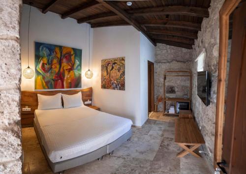 a bedroom with a bed and a painting on the wall at Casa Alegre Alaçatı in Alaçatı