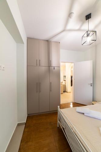 ein Schlafzimmer mit weißen Schränken und einem Bett in der Unterkunft Kariatides in Sparta