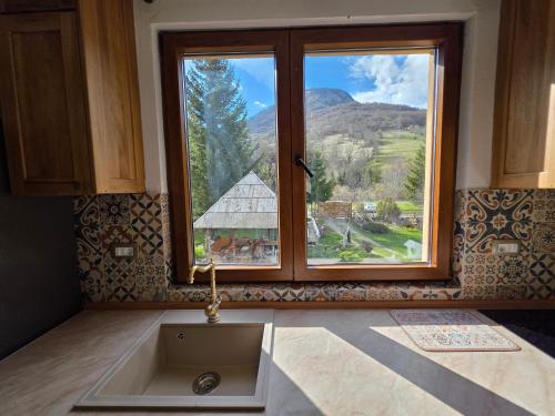 a kitchen with a sink and a large window at Ethno Village Štitarica in Mojkovac