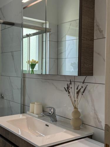 a bathroom with a sink and a mirror at Lūm Posidonia in Posidhonía