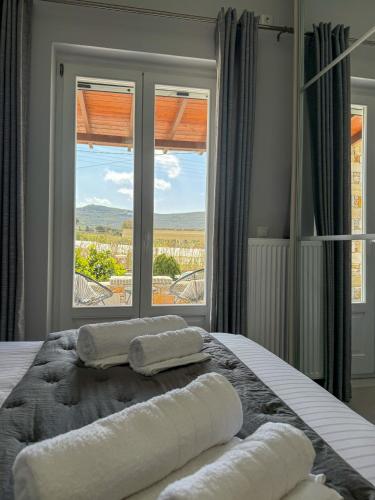 a bedroom with a bed with two towels on it at Lūm Posidonia in Posidhonía