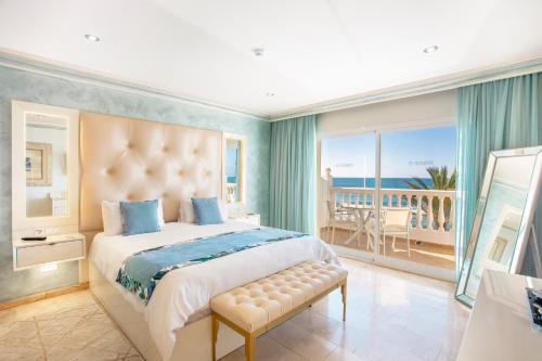 a bedroom with a bed and a balcony with the ocean at El Oceano Beach Hotel Adults only recommended in La Cala de Mijas