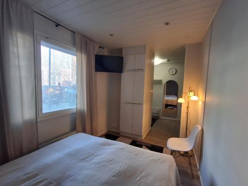 a bedroom with a bed and a chair and a window at Easy Stay Mikkeli in Mikkeli