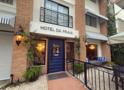 a hotel da praia building with a blue door at Hotel da Praia in Vila Velha