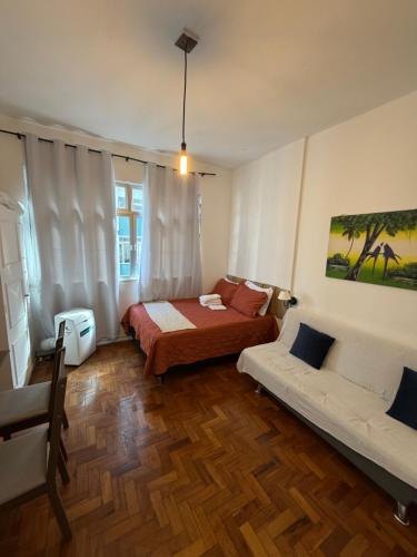 a bedroom with a bed and a couch in it at Apartamento Centro Imperial de Petrópolis in Petrópolis