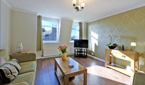 a living room with a couch and a coffee table at Home from Home Aberdeen-Spacious West End Apartment-Free Parking-Near ARI & City Centre in Aberdeen