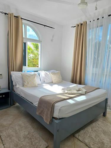 a bedroom with a large bed with a window at Malindi Getaway, Near Beach in Malindi