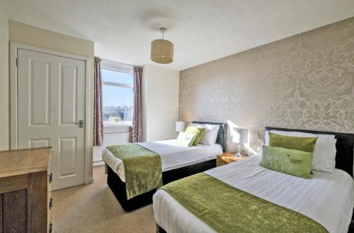 a hotel room with two beds and a window at Home from Home Aberdeen-Spacious West End Apartment-Free Parking-Near ARI & City Centre in Aberdeen
