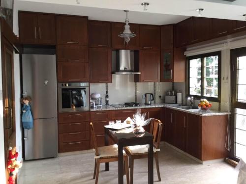 a kitchen with wooden cabinets and a table with chairs at Nikola's House in Limassol
