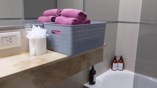 a bathroom with a shelf with purple towels and a sink at Apart Rilax in Buenos Aires