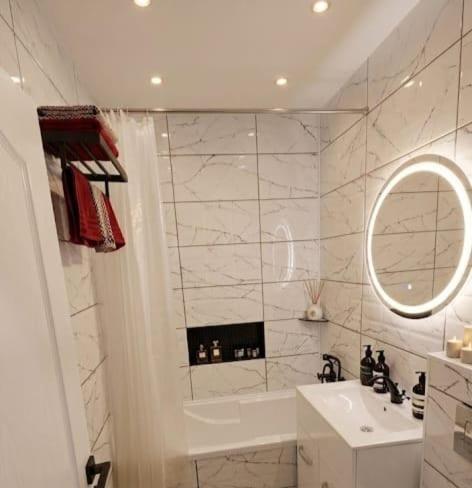 a white bathroom with a sink and a mirror at Old City Cafe in Brăila