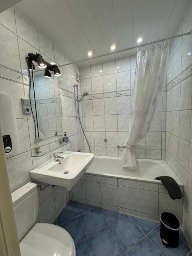 a bathroom with a sink and a tub and a toilet at Beachpoint-Fehmarn in Burgtiefe auf Fehmarn 
