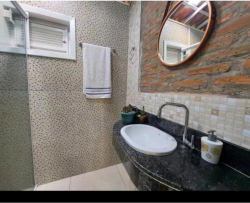 a bathroom with a sink and a mirror at Chalé Guaíras in Mulungu