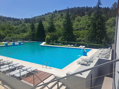 a swimming pool with chairs and a mountain in the background at São Cristóvão Nature Country Hotel in Venda Nova