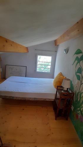 a bedroom with a large bed and a window at Verdure, rivière et vue imprenable in Sallelles