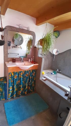 a bathroom with a sink and a tub and a mirror at Verdure, rivière et vue imprenable in Sallelles