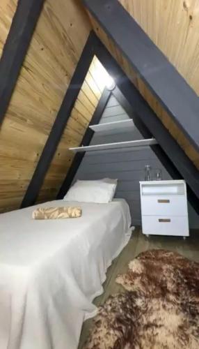 a bedroom with a white bed and a night stand at Luz de Cabana in Santo Amaro da Imperatriz