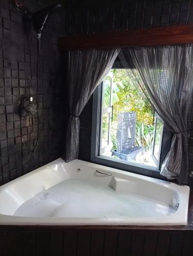 a bath tub in a room with a window at Luz de Cabana in Santo Amaro da Imperatriz