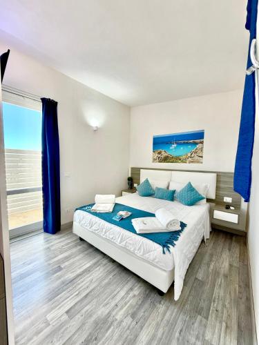 a bedroom with a large bed with blue pillows at Stabilimento Lido Burrone in Favignana