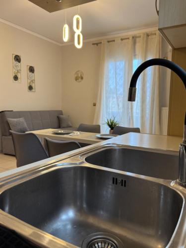 a kitchen with a sink and a living room at K A P Home in Chios